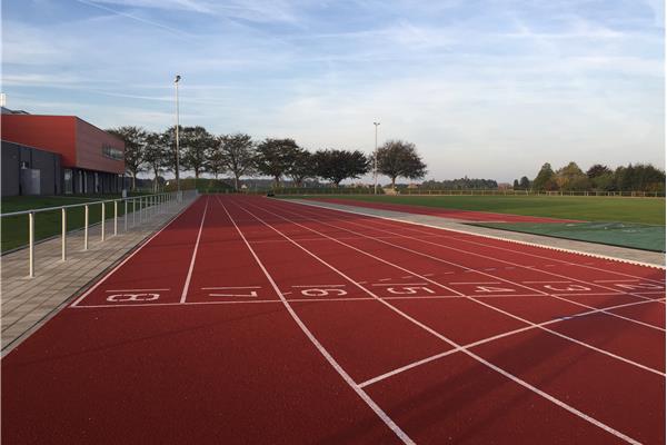 Aanleg kunststof atletiekpiste in PU, natuurgras voetbalveld en omgevingswerken - Sportinfrabouw NV